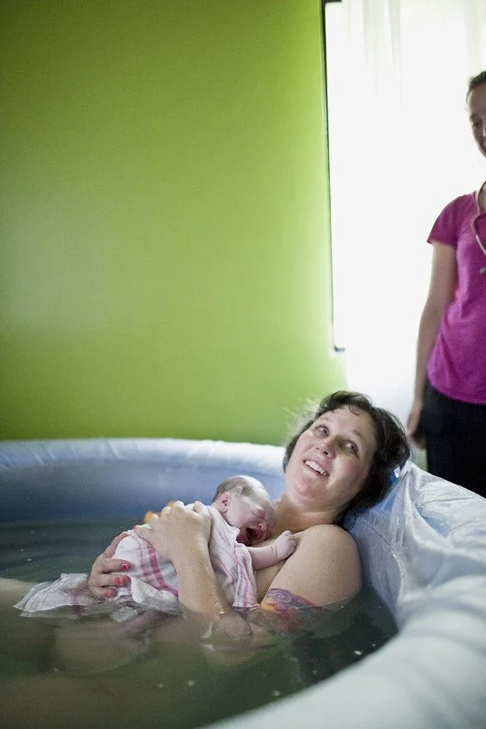 mother smiles after delivery in water pool